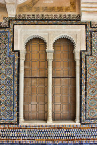Verziertes Doppelfenster mit Hufeisenbögen, Marmorsäulen und buntem Mosaikrahmen