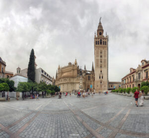 Panoramaaufnahme der Kathedrale von Sevilla mit Giralda-Turm und umliegendem Platz