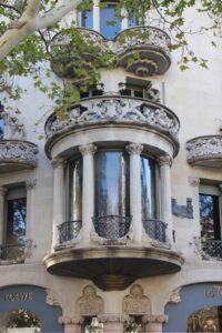 Verzierter Jugendstil-Erker mit Säulen, floralen Ornamenten und Glasfenstern