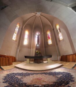 Innenansicht einer Kapelle mit Altar, Lichteinfall und bunten Glasfenstern