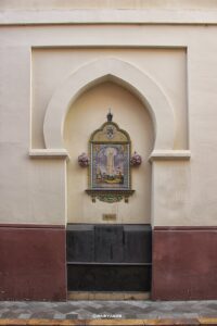 Religiöse Wandnische mit Madonnenbild und Blumen