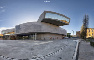 Weitwinkelaufnahme des MAXXI Museums in Rom, einem architektonisch einzigartigen Betongebäude mit weit auskragenden Elementen und großen Glasflächen, bei Tageslicht.